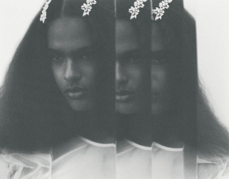 Monochrome portrait of a model with long dark hair and floral hairpins, captured with multiple slice exposures.