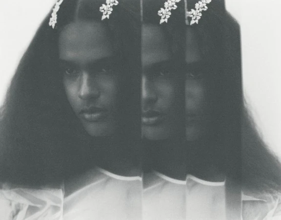 Monochrome portrait of a model with long dark hair and floral hairpins, captured with multiple slice exposures.