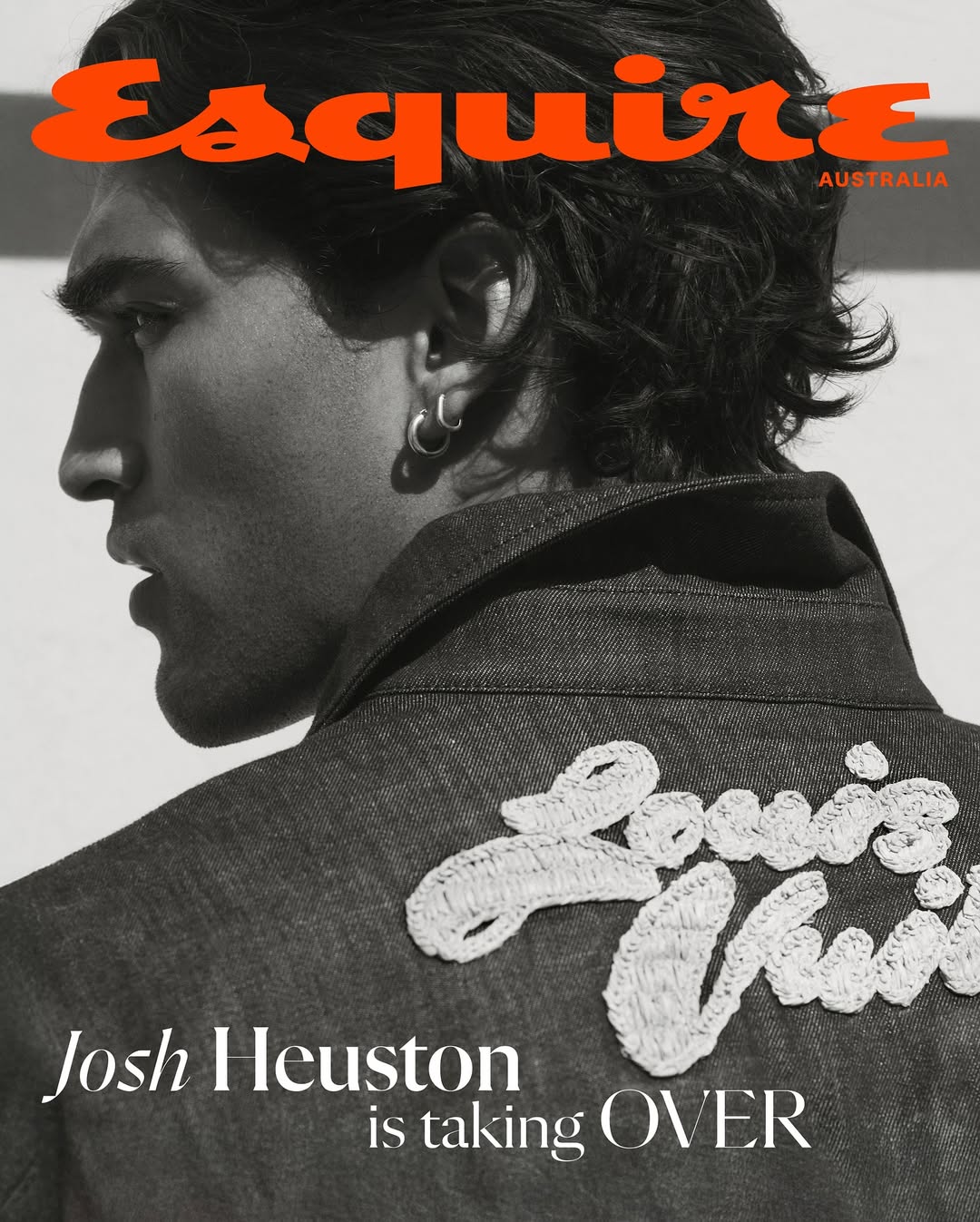 Esquire Australia cover featuring a man with dark hair wearing a denim jacket with embroidered lettering, shot in a photo studio.