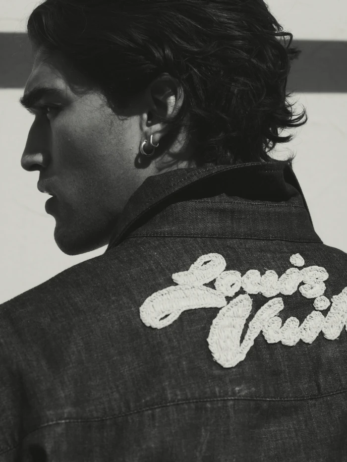 Close-up profile of Josh Heuston wearing a dark denim jacket with embroidered white lettering for Esquire Australia.