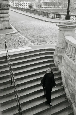 Model Liz Kennedy walking down classical stone outdoor stairs wearing a black outfit for Almada S/S 2026