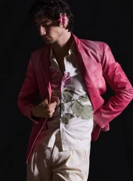 Milo Manheim wearing a pink blazer and floral shirt against a black background for V Man photographed by David Roemer