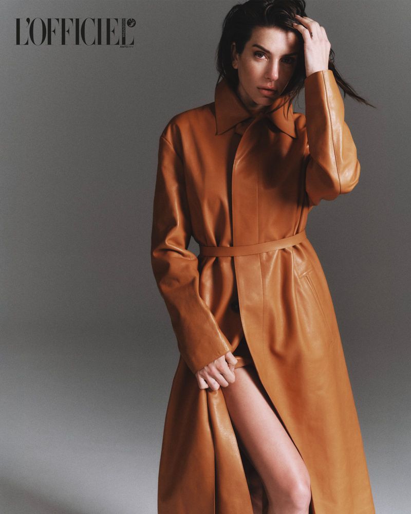 Model wearing a brown leather coat against a grey studio seamless background for L'Officiel Argentina