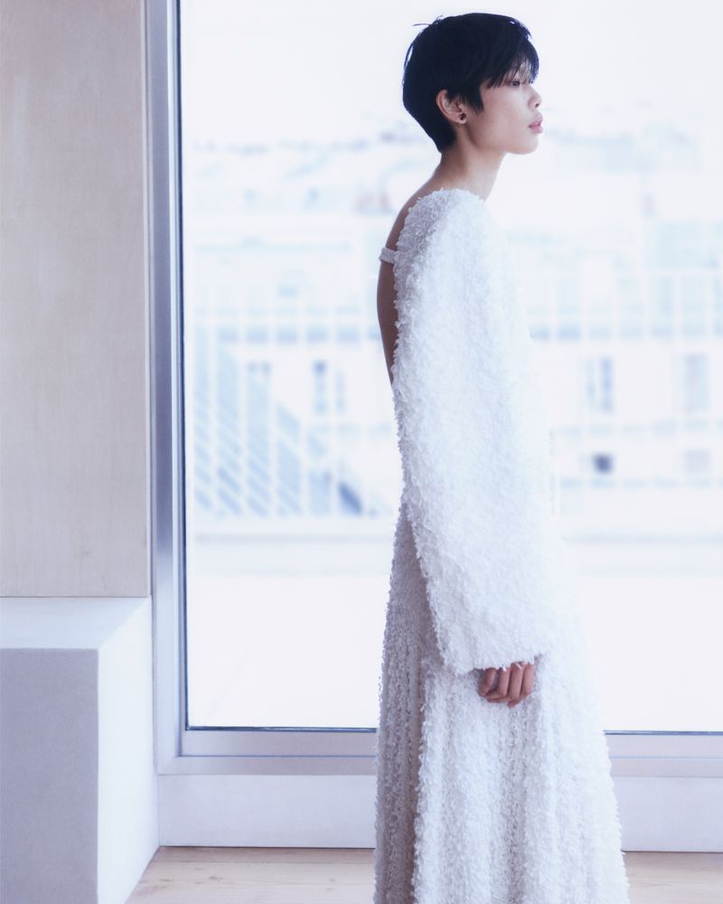 Model Kayako Higuchi in a textured white dress standing near a bright window for CR Fashion Book Bottega Special