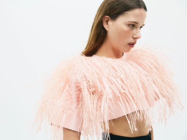Model wearing a pink fringed top against a plain white studio background for CR Fashion Book PLEIN SOLEIL