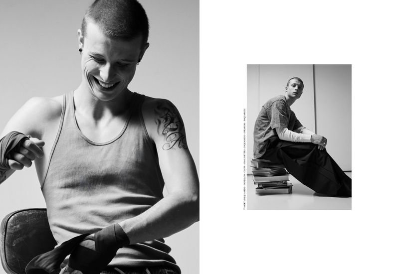 Black and white editorial portrait of actor Francesco di Tullio wrapping his hands for boxing, smiling with a tattooed arm.