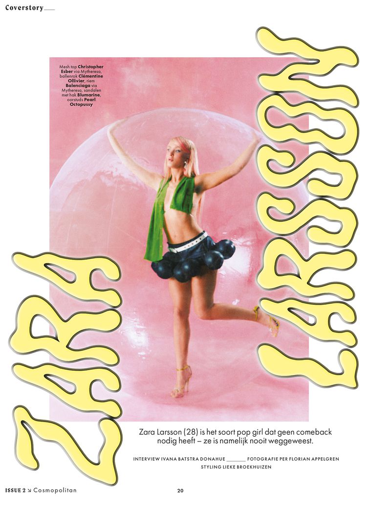 Zara Larsson posing inside a giant transparent pink sphere wearing a green scarf and dark skirt with spherical accents
