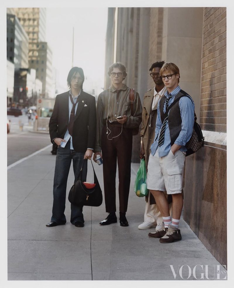 Four male models posing on a city sidewalk for a Vogue China Men fashion editorial photographed by Javier Castan.
