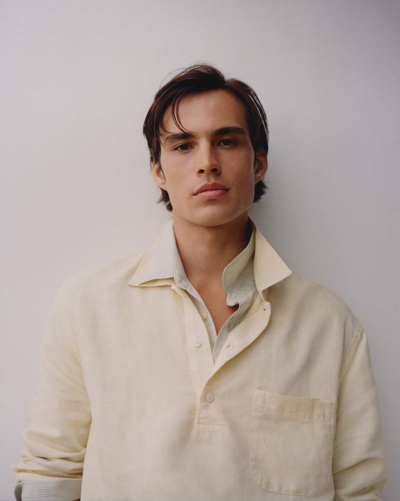 Portrait of Louis Baines wearing a cream buttoned shirt against a plain white background for Zara Man Spring 2026