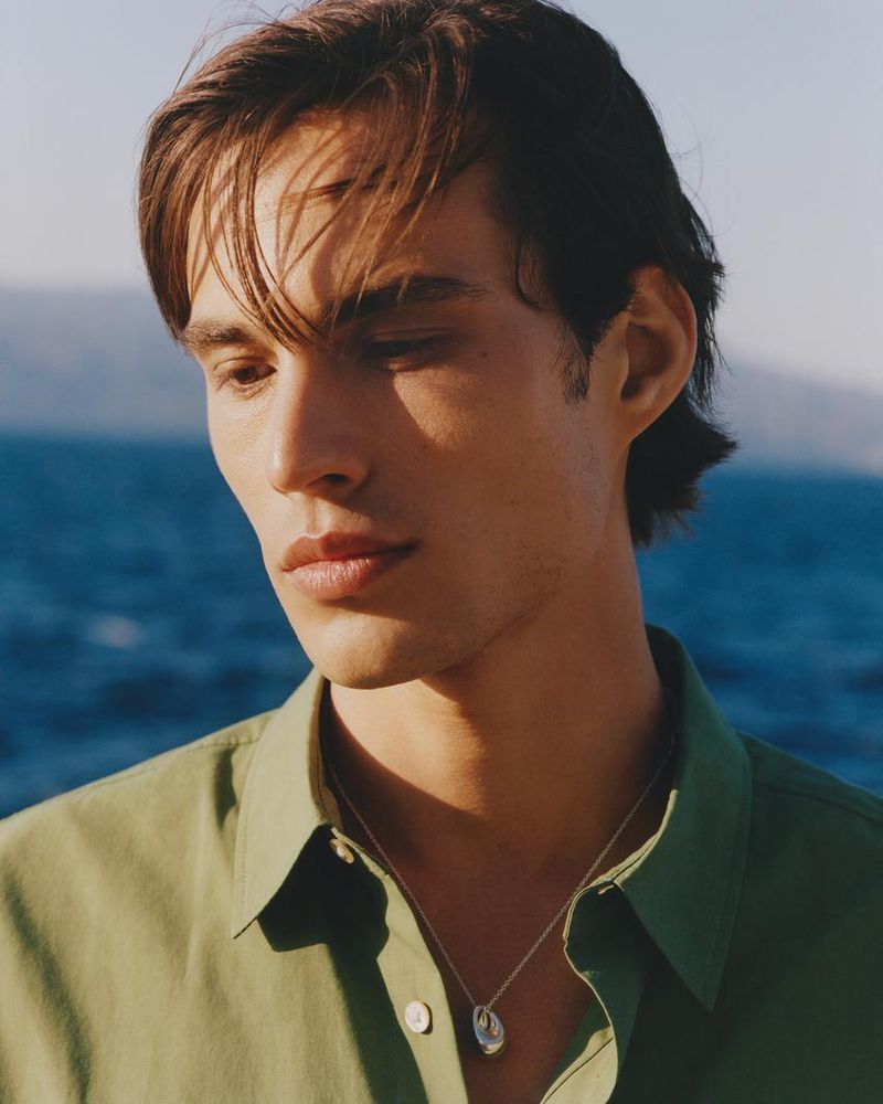 Portrait of Louis Baines wearing a green shirt against an ocean background for Zara Man Spring 2026.