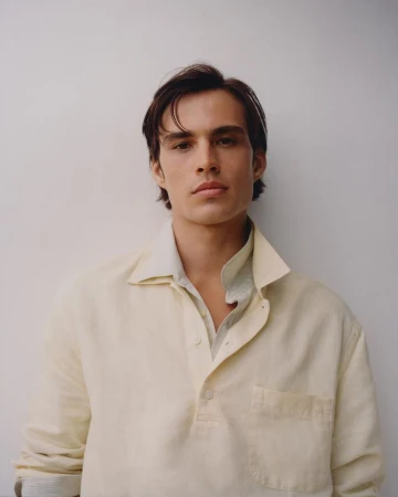 Portrait of Louis Baines wearing a cream buttoned shirt against a plain white background for Zara Man Spring 2026