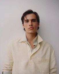 Portrait of Louis Baines wearing a cream buttoned shirt against a plain white background for Zara Man Spring 2026