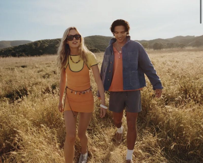 Two models walking together through a dry grassy field under an open sky, photographed by Ben Toms for Zara.