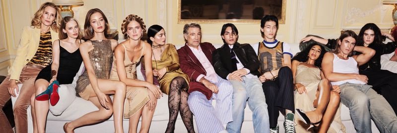 Group of diverse models and actors seated together on a sofa in a luxury hotel interior for an Hourglass cosmetics campaign.