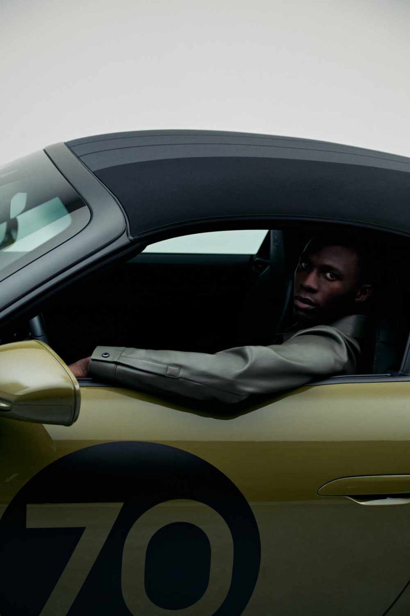 Man seated inside a green sports car with number 70 on the door for the Porsche x Boss campaign by BOSS.