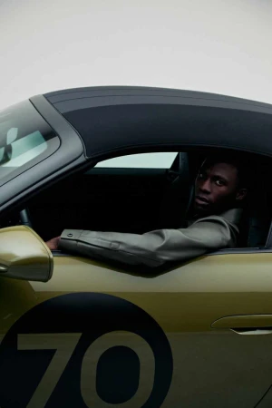 Man seated inside a green sports car with number 70 on the door for the Porsche x Boss campaign by BOSS.