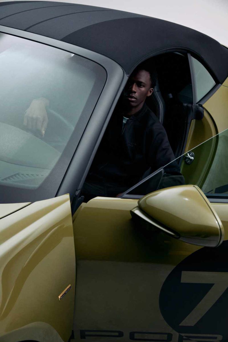 Man seated inside a luxury green convertible car with a dark top for the Porsche x Boss campaign by BOSS.
