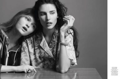 Two female models posing together in black and white for a Pop Magazine editorial shot against a grey studio backdrop.