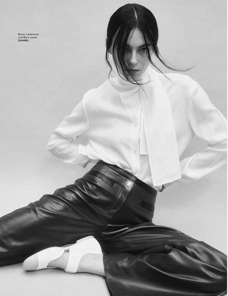 Model in white blouse and dark leather trousers sitting against a plain studio background for Flair Germany Wondelbar editorial