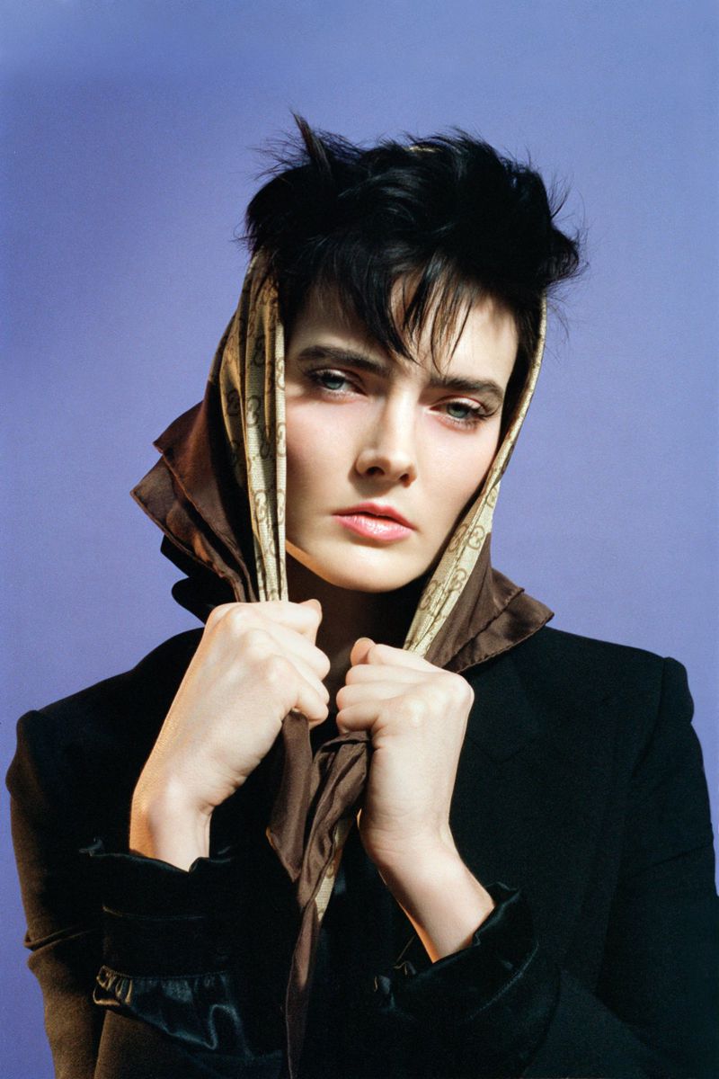 Model wearing a headscarf and dark jacket against a purple background for SSAW Magazine