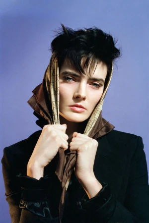 Model wearing a headscarf and dark jacket against a purple background for SSAW Magazine