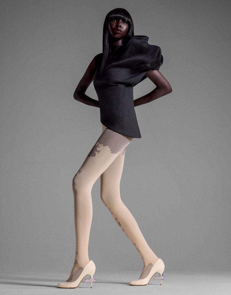 Model Ajok Madel wearing structured black top and patterned tights in a fashion editorial for Enfnts Terribles, photographed by Yis Kid.