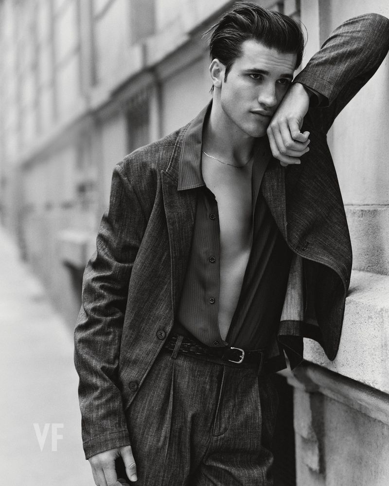 Model Max Knott leaning against an exterior wall in a suit jacket, photographed by Zeb Daemen for Vanity Fair Italia.
