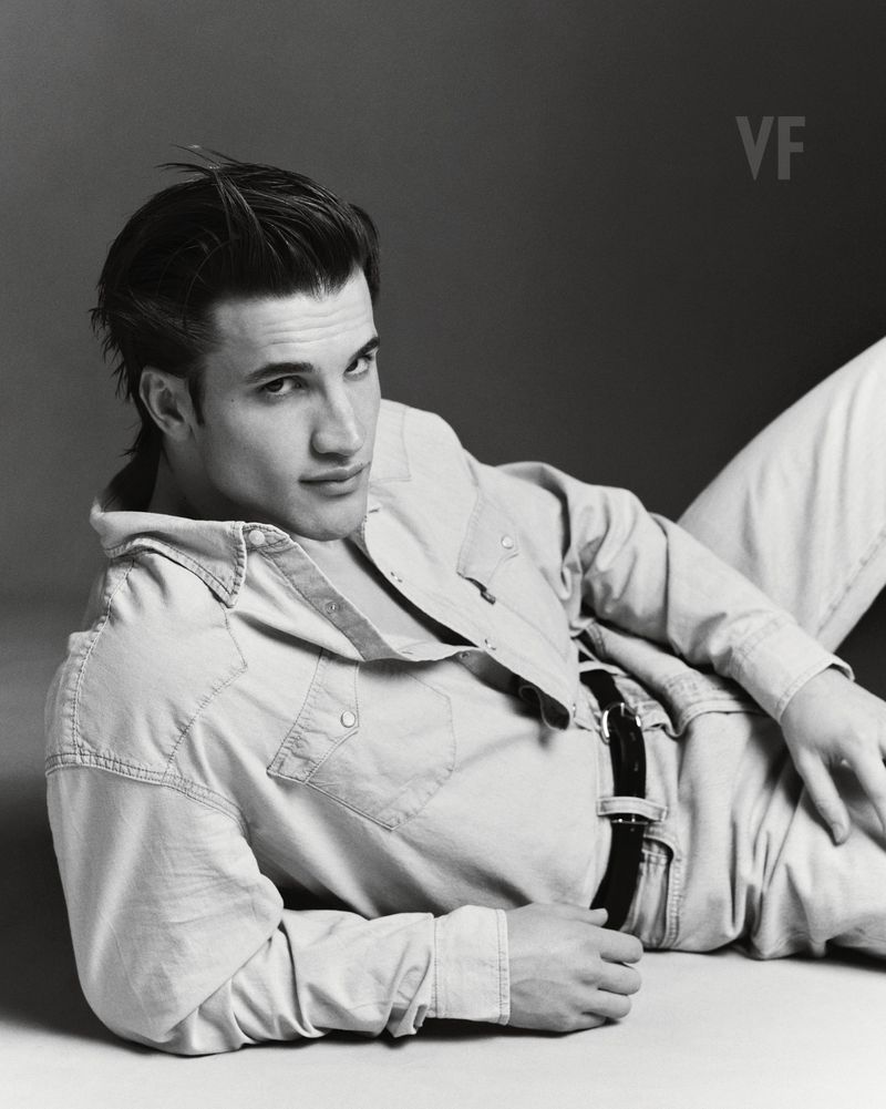 Portrait of Max Knott in a denim shirt and jeans lying on a light studio backdrop for Vanity Fair Italia