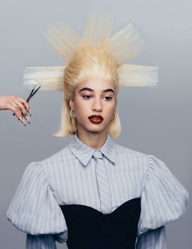 Model with elaborate blonde avant-garde spiked hair holding scissors near head for Tush Magazine editorial
