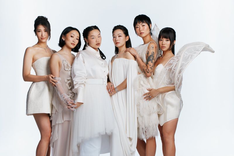 Group of six women in white and neutral dresses posing together against a plain white background for Variety Magazine