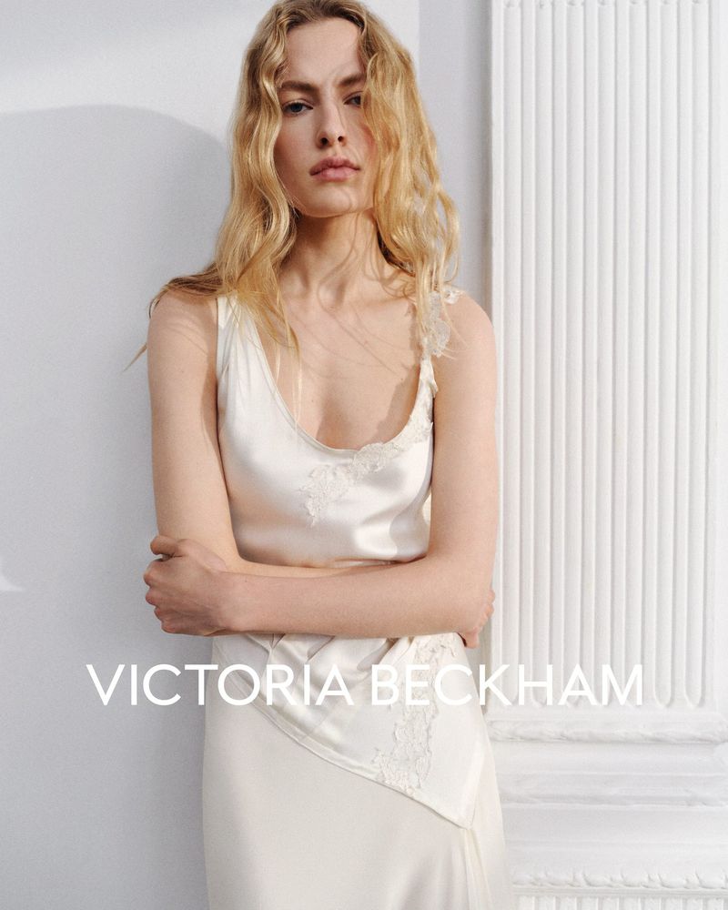 Model Felice Nova Noordhoff in an ivory silk slip dress posing against an interior wall for Victoria Beckham.