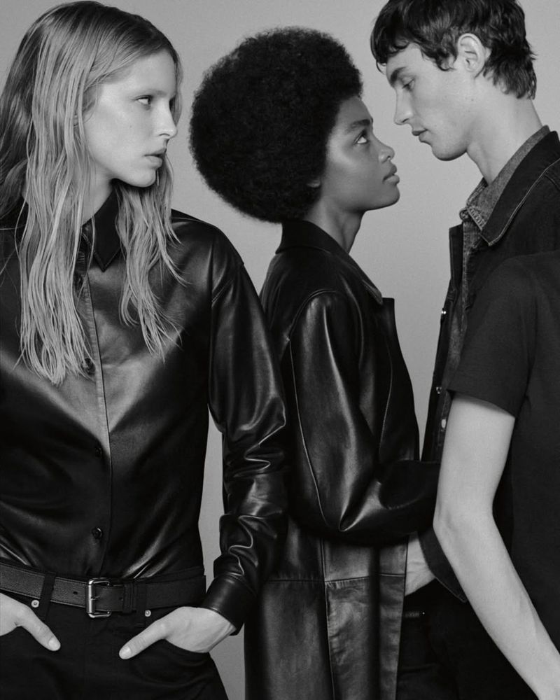 Monochrome fashion portrait of three models posing against a neutral backdrop for Calvin Klein campaign.