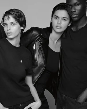 Black and white portrait of a group of models wearing black apparel against a solid seamless studio background.