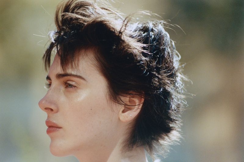 Profile portrait of a woman with short dark hair in natural lighting for Hube Magazine editorial Raw distance