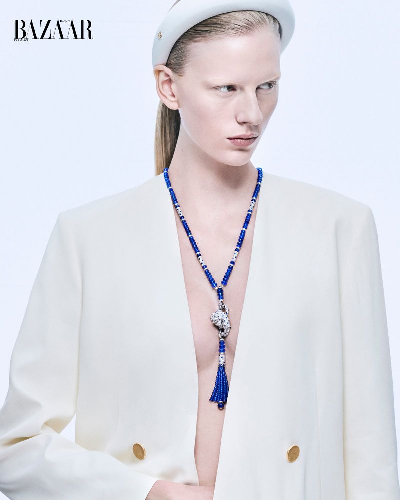 Model wearing a white blazer, blue beaded necklace, and headband against a light studio backdrop for Harper's Bazaar Mexico.