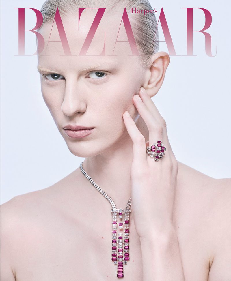 Close-up portrait of a female model wearing diamond and ruby jewellery against a clean white seamless studio background.