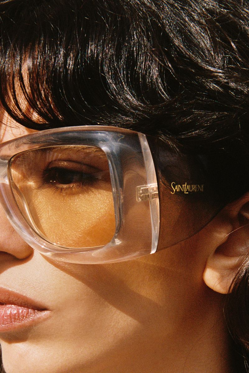 Close up portrait of a woman wearing oversized translucent sunglasses with amber tinted lenses