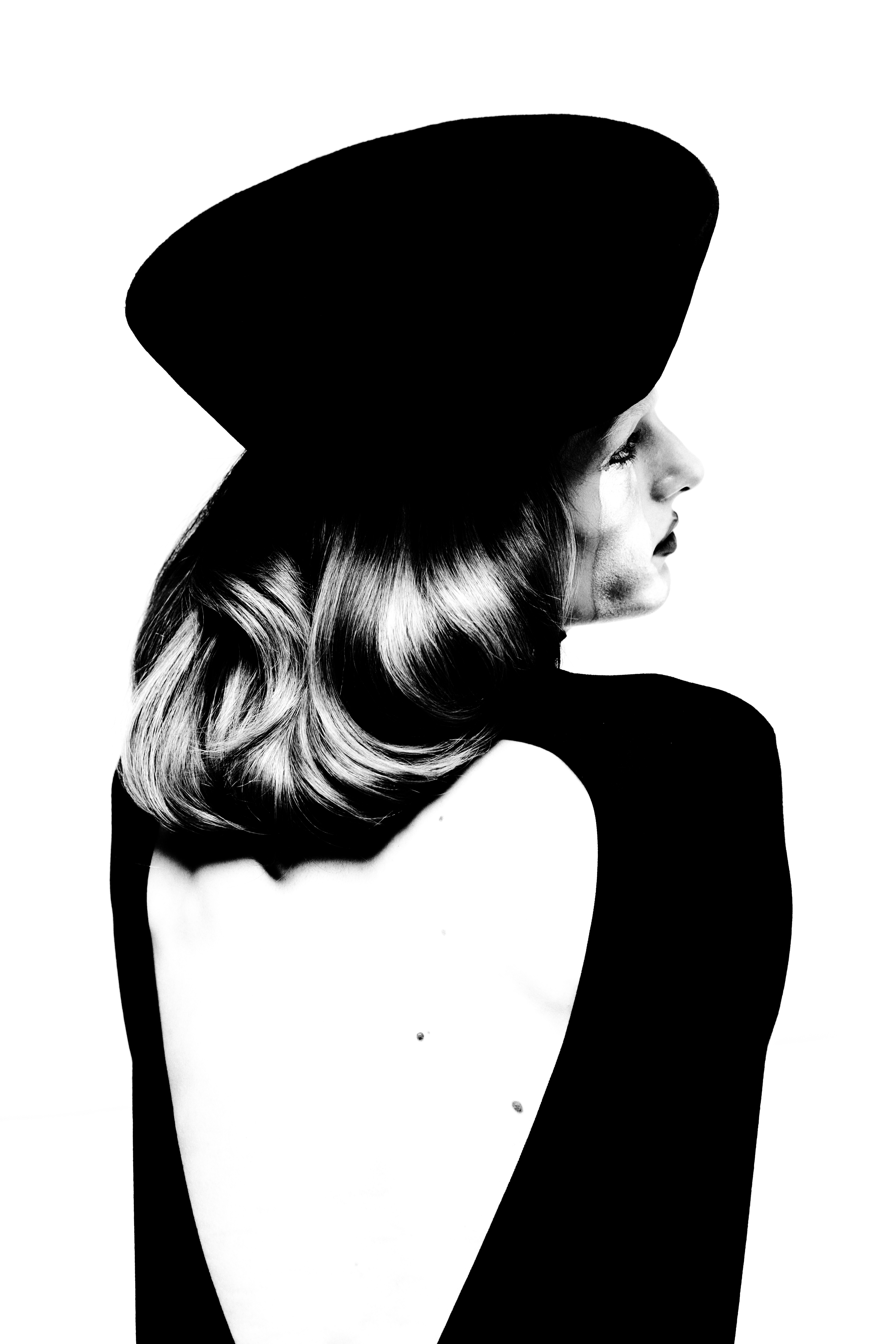 Model in backless black top and hat against a stark white background for Numero Netherlands ORNAMENTA