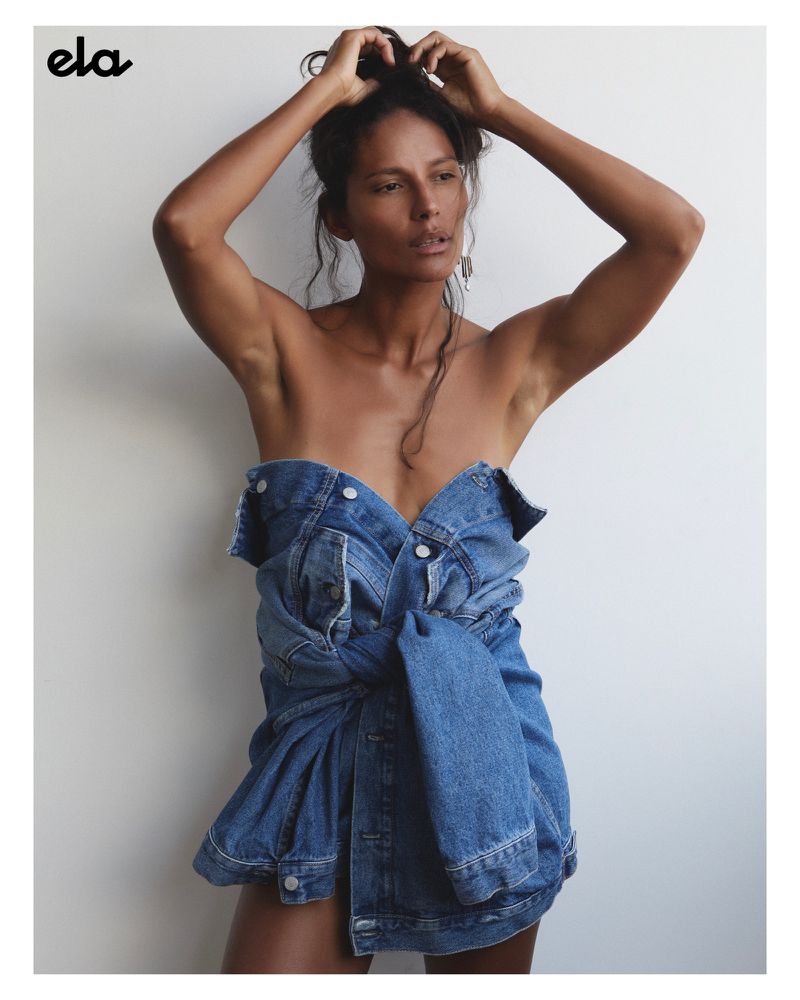 Portrait of a dark-haired woman wearing a denim jacket, shot in a photo studio against a neutral background with soft lighting.