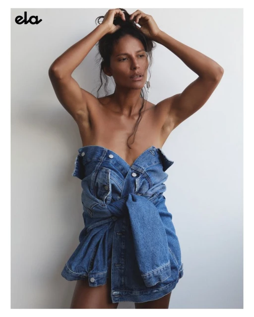 Portrait of a dark-haired woman wearing a denim jacket, shot in a photo studio against a neutral background with soft lighting.