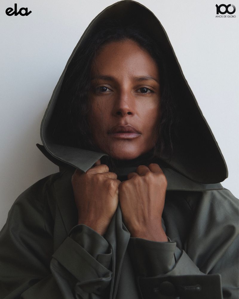 Model Emanuela de Paula wearing a dark hooded coat, captured in a close portrait for ELA O Globo by photographer Higor Bastos.