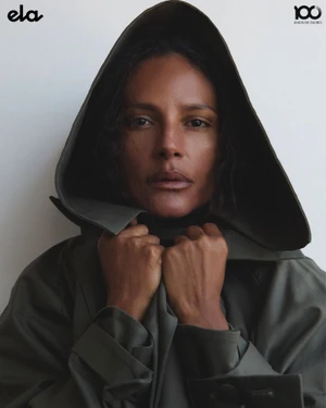 Model Emanuela de Paula wearing a dark hooded coat, captured in a close portrait for ELA O Globo by photographer Higor Bastos.