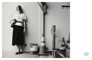 Carey Mulligan wearing a visor and carrying a handbag, standing against an architectural wall for Pop Magazine.