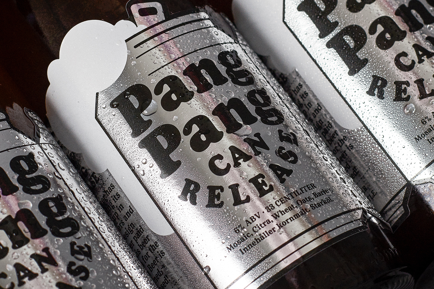 Close-up of chilled, condensation-covered PangPang beer cans with metallic silver labels and bold typography designed by Jens Nilsson.