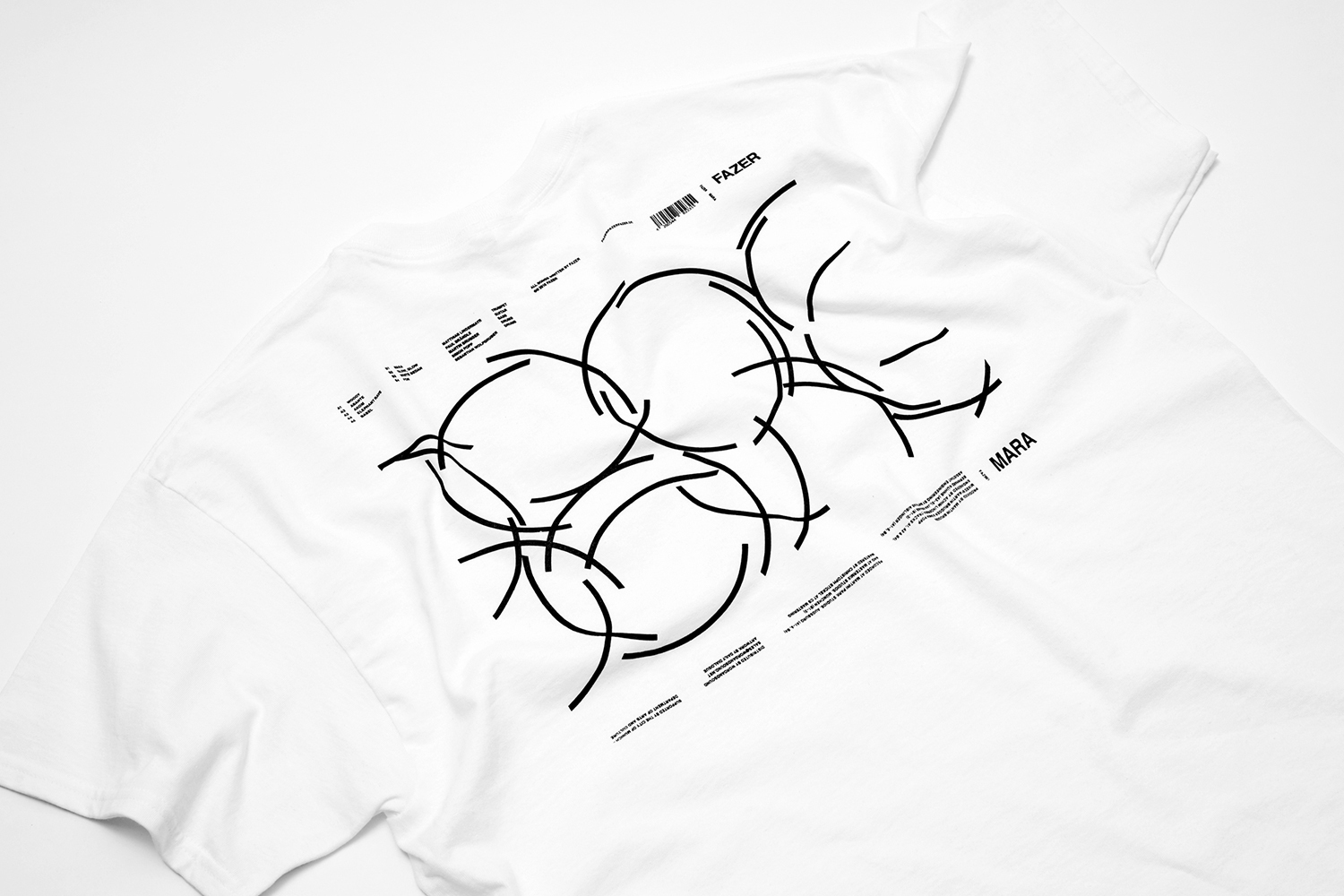 White t-shirt featuring black circular geometric line art and typography on the back, displayed on a white surface.