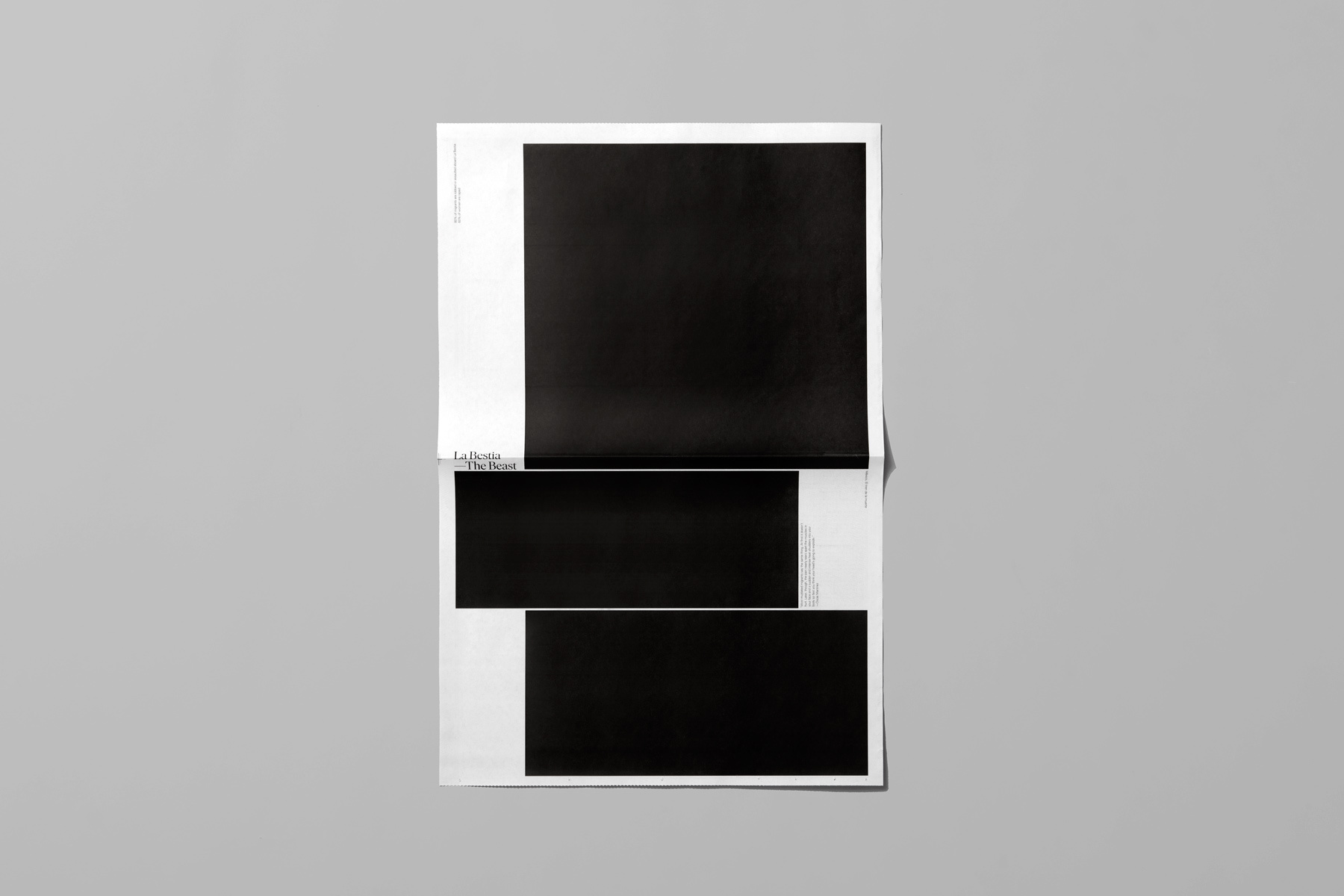Minimalist graphic design layout with stark black rectangular blocks on white paper against a plain grey backdrop.