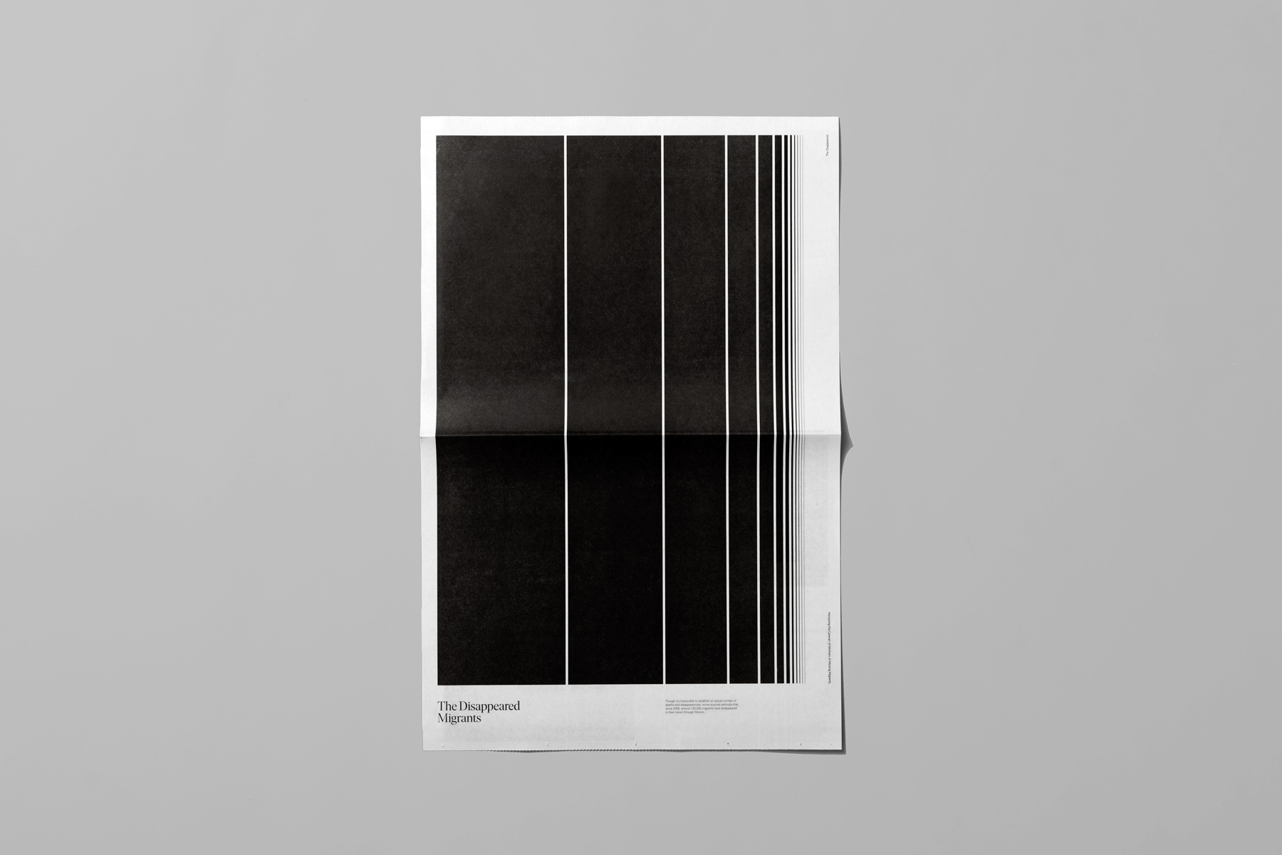 A black and white poster with vertical lines and text resting on a plain grey surface.