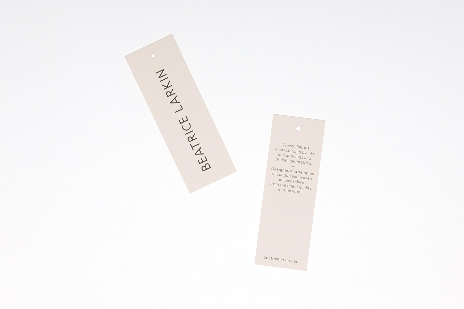 Two rectangular branded paper tags with black typography against a plain white background