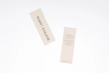 Two rectangular branded paper tags with black typography against a plain white background