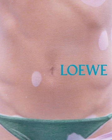 Close-up torso detail wearing dark green bikini bottoms with teal typography overlay for Loewe